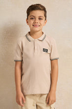 Load image into Gallery viewer, قميص بولو للأولاد باللون البيج مع شعار على الصدر وياقة مائلة
